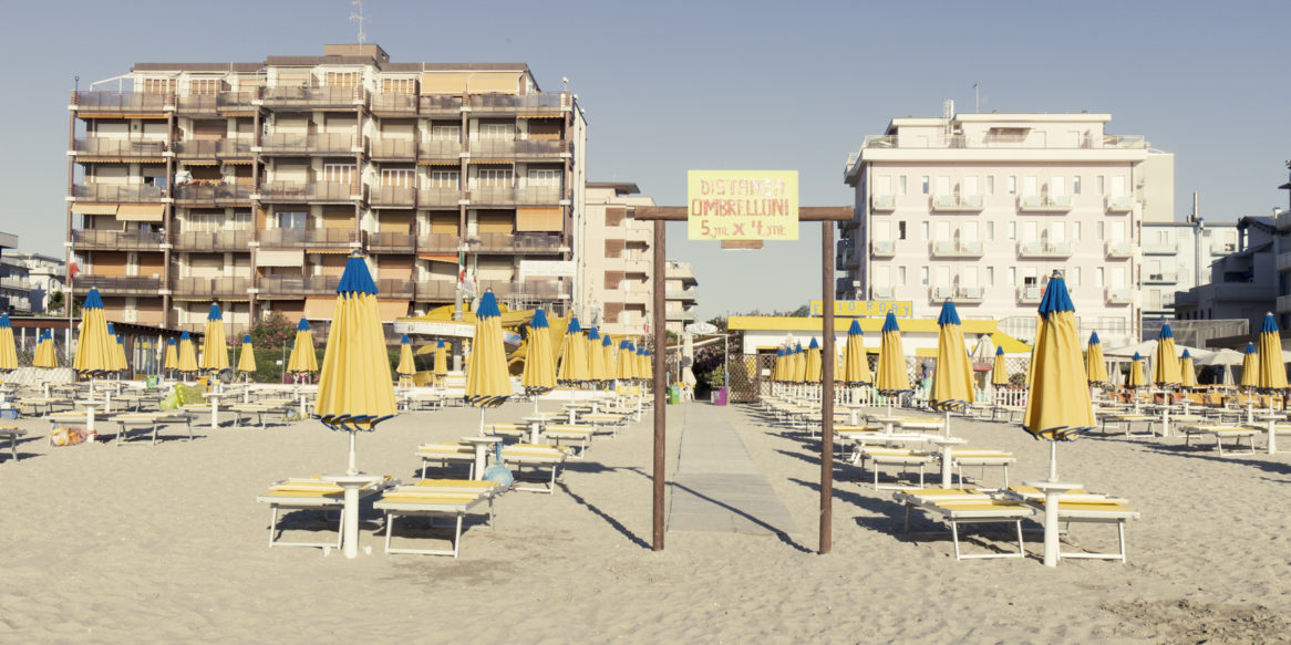 Con piedi nell’acqua e il mare alle spalle